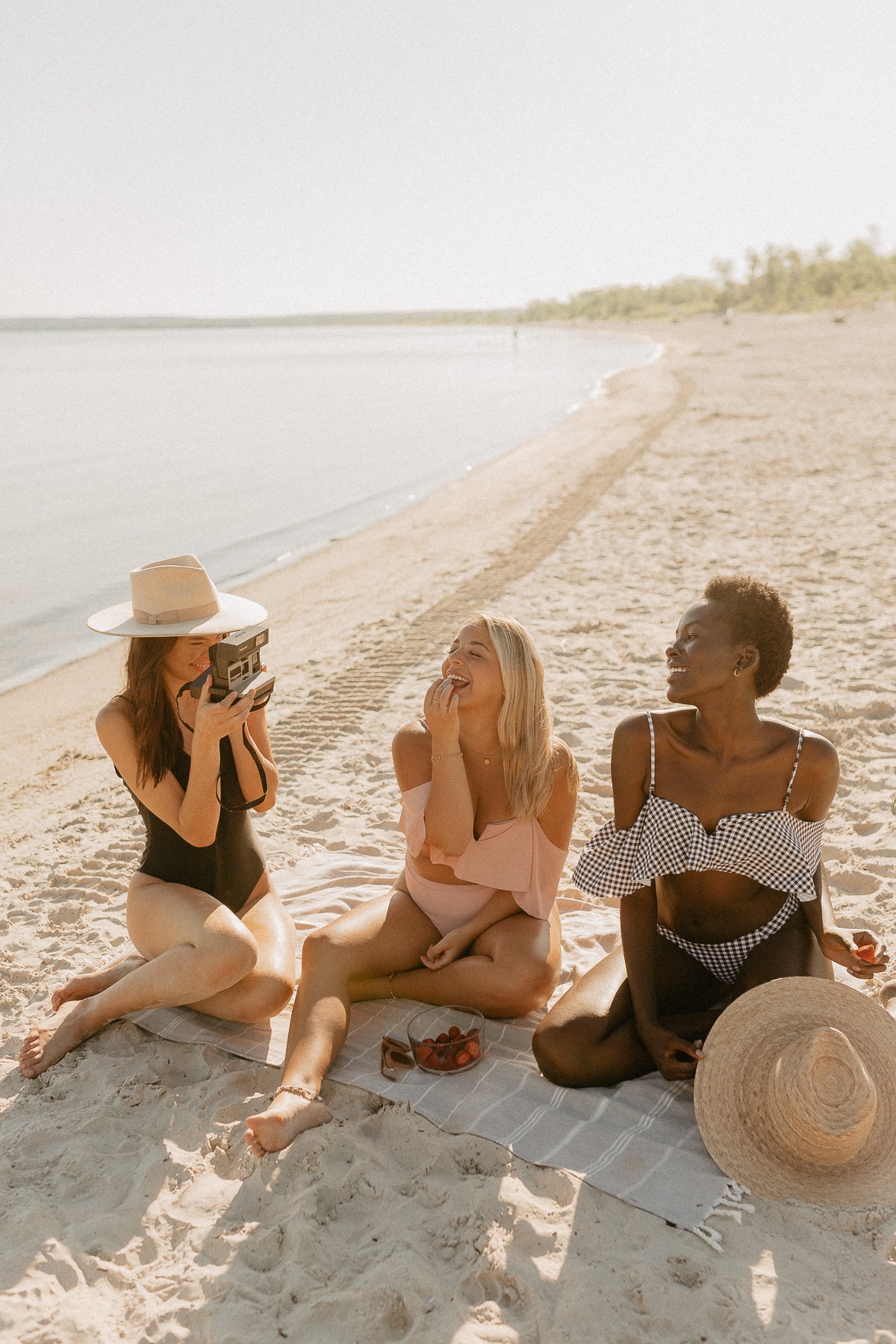 Models on North American swimwear brand Prairie swim quick-drying, neutral woven beach towel with tassles