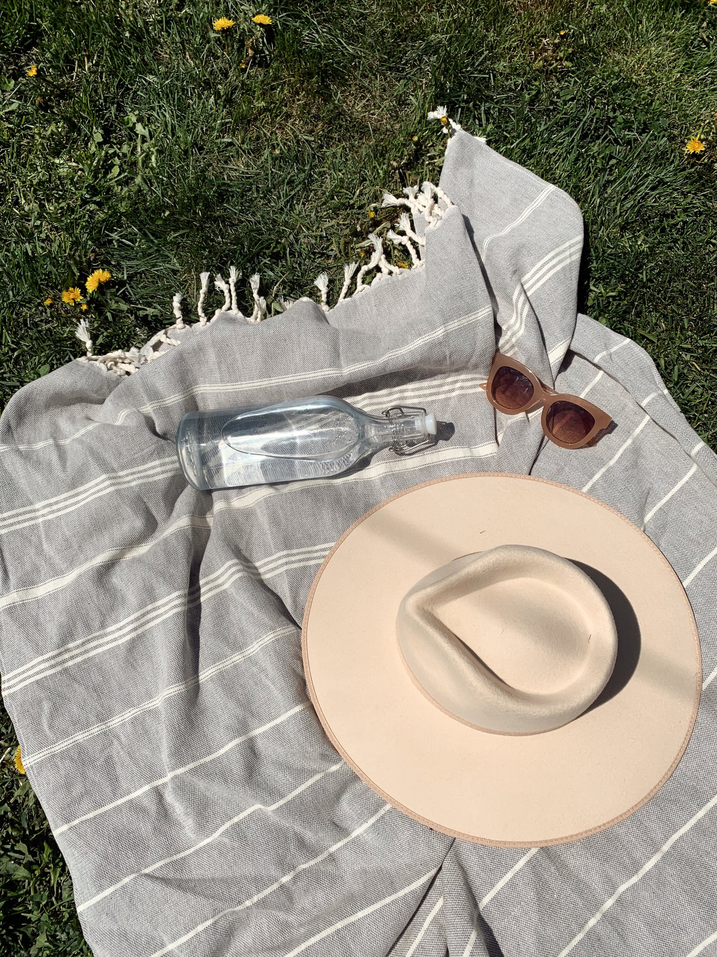 Models on North American swimwear brand Prairie swim quick-drying, neutral woven beach towel with tassles